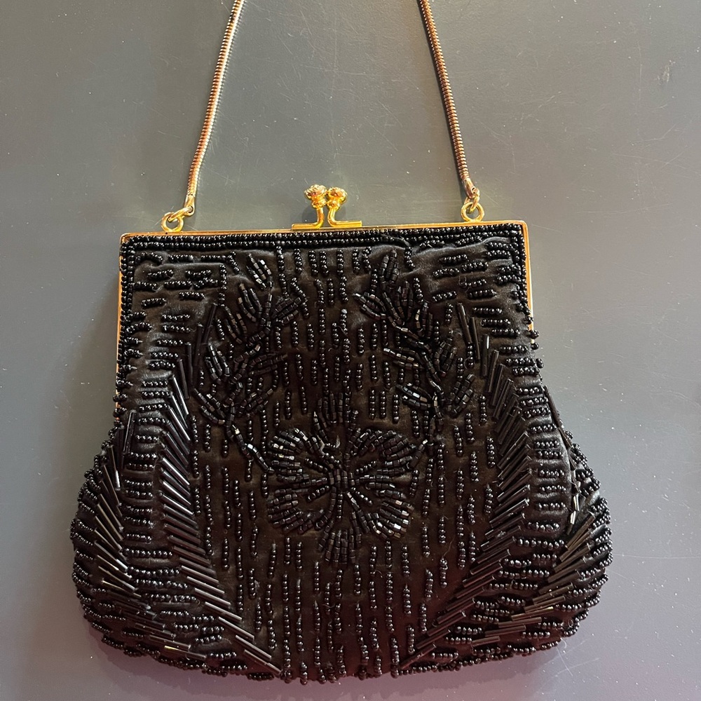 Small black beaded evening clutch with gold tone chain handle.